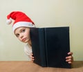 ÃÂ¡ute girl in Santa Claus hat with big blue book.